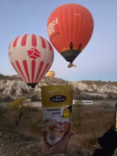 Kemasan pouch Permen Jahe Padjajaran dipegang di depan balon udara Cappadocia, Turki